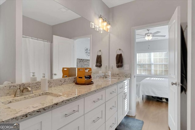 bathroom with wood-type flooring, vanity, and ceiling fan