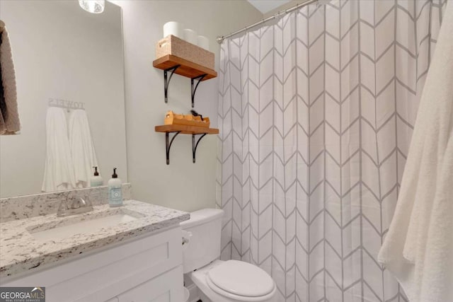 bathroom featuring walk in shower, vanity, and toilet