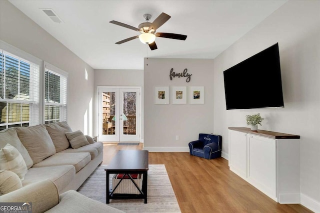 living room with ceiling fan, light hardwood / wood-style floors, and french doors