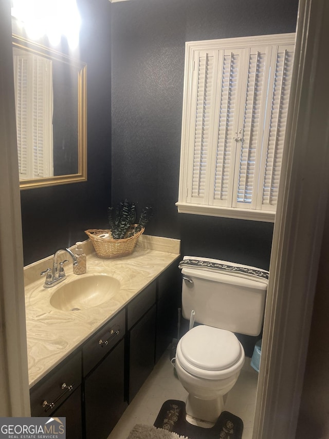 bathroom featuring tile patterned floors, vanity, and toilet