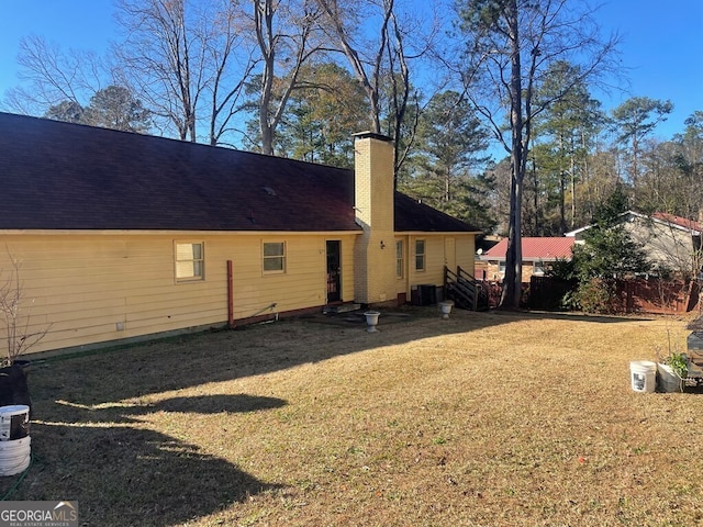 back of property with a yard and central air condition unit