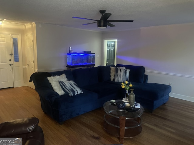 living room featuring ceiling fan, crown molding, wood-type flooring, and a textured ceiling