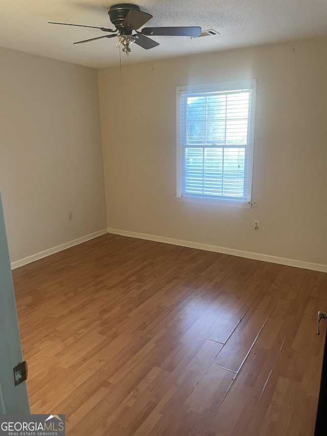 unfurnished room with hardwood / wood-style flooring, ceiling fan, and a textured ceiling