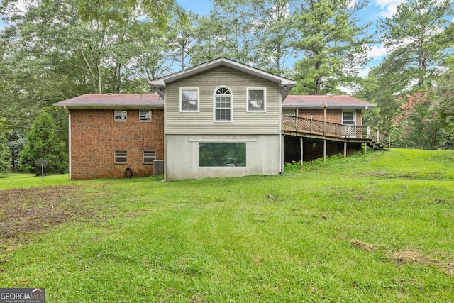 rear view of house with a yard and a wooden deck