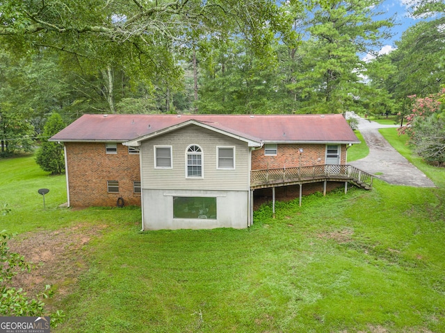 back of house with a deck and a lawn