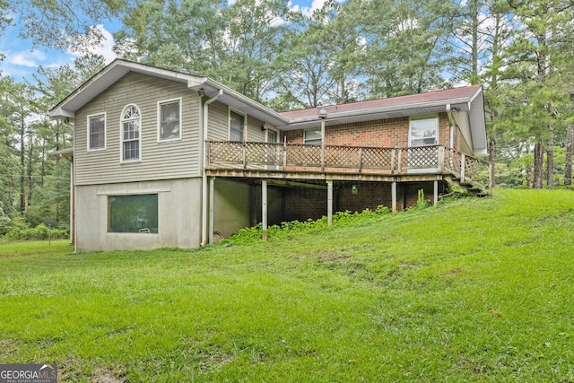 back of house featuring a lawn and a wooden deck