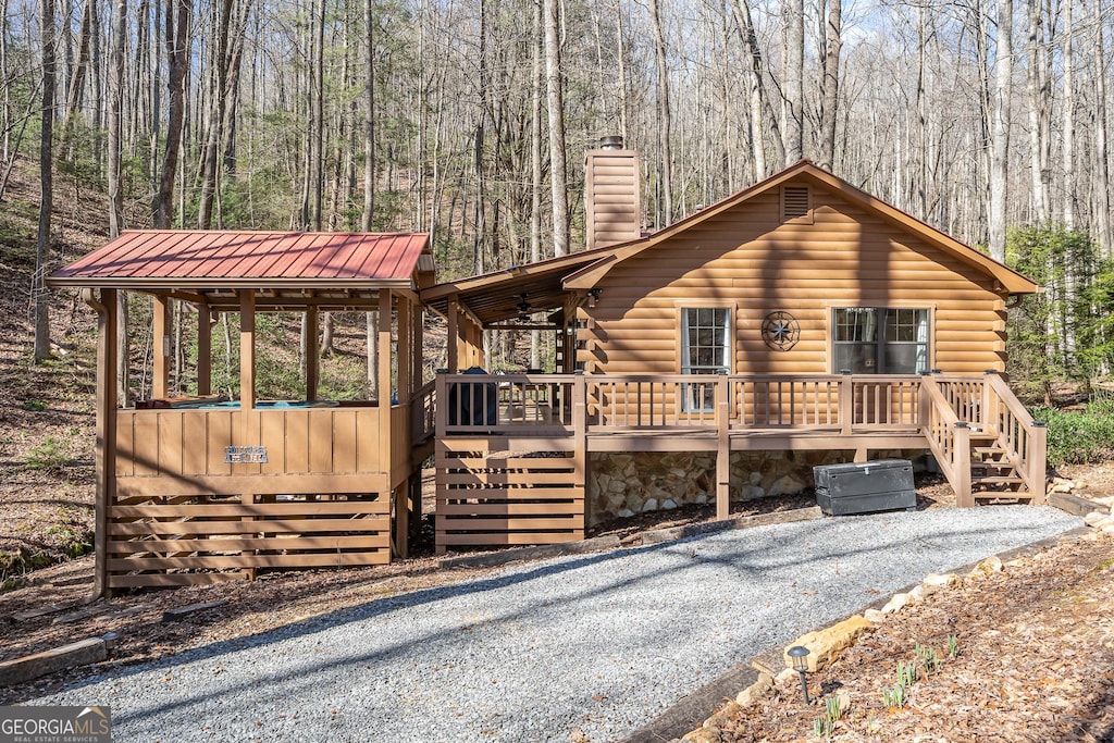 log cabin with ceiling fan and a deck