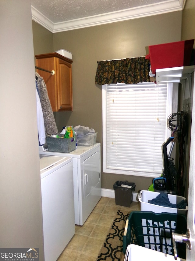 clothes washing area with separate washer and dryer, crown molding, cabinets, and a textured ceiling