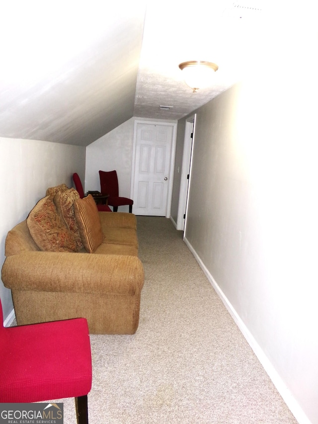 living area with carpet and vaulted ceiling