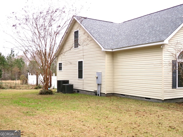 view of property exterior featuring central AC unit and a lawn