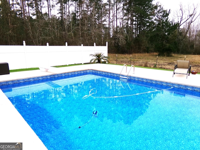 view of swimming pool with a diving board