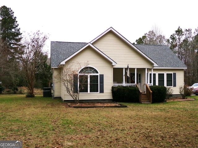 rear view of property featuring a lawn, covered porch, and central AC