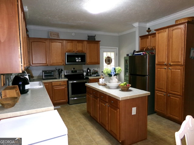 kitchen featuring a textured ceiling, a kitchen island, crown molding, and stainless steel appliances