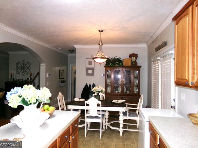 kitchen with hanging light fixtures, a textured ceiling, and ornamental molding