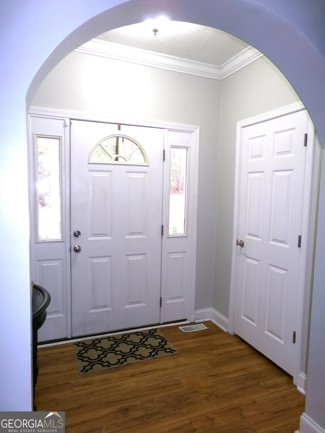 entryway featuring dark hardwood / wood-style flooring and ornamental molding