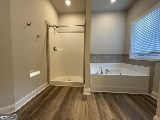 bathroom with wood-type flooring and plus walk in shower