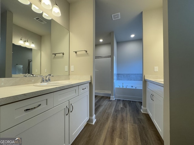 bathroom featuring a bath, vanity, and wood-type flooring