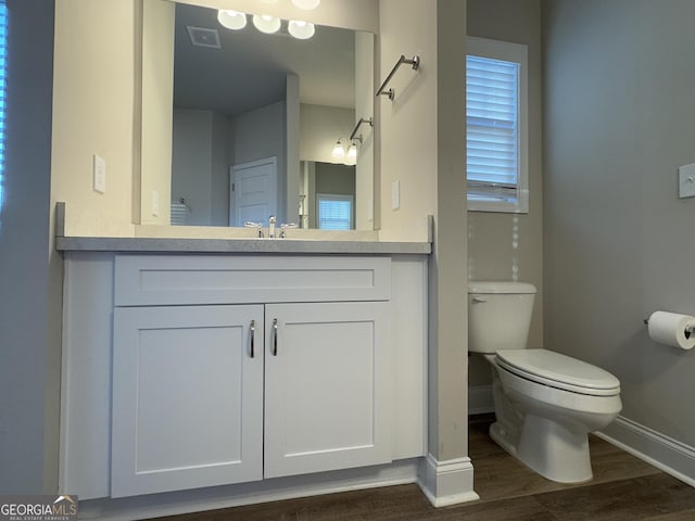 bathroom featuring wood-type flooring, vanity, and toilet