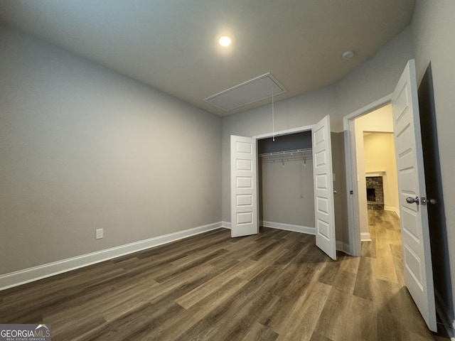 unfurnished bedroom featuring a closet and dark wood-type flooring