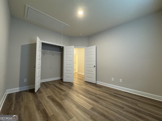 unfurnished bedroom featuring a closet and dark wood-type flooring