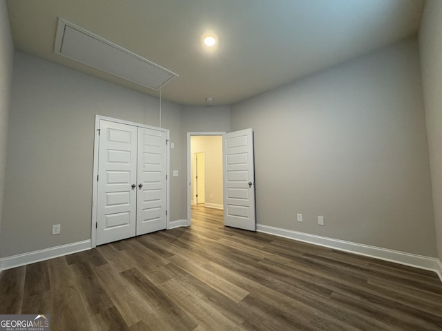 unfurnished bedroom with dark hardwood / wood-style flooring and a closet