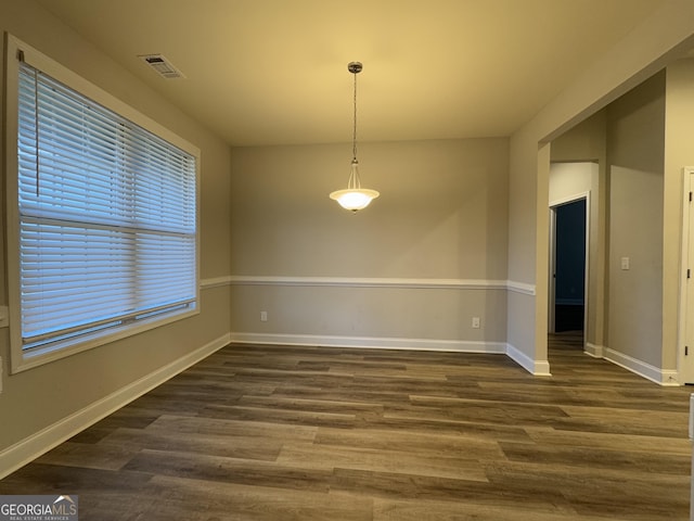 unfurnished dining area featuring plenty of natural light and dark wood-type flooring