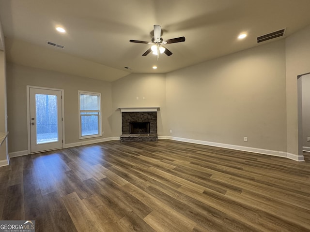 unfurnished living room featuring lofted ceiling, a fireplace, ceiling fan, and dark hardwood / wood-style floors