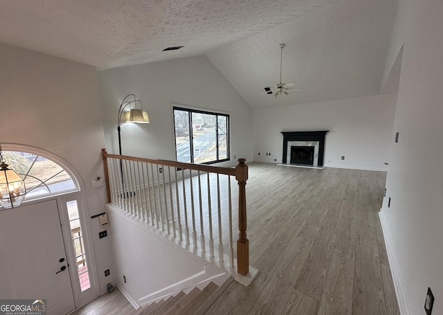 entrance foyer with a healthy amount of sunlight, wood-type flooring, a fireplace, and a textured ceiling