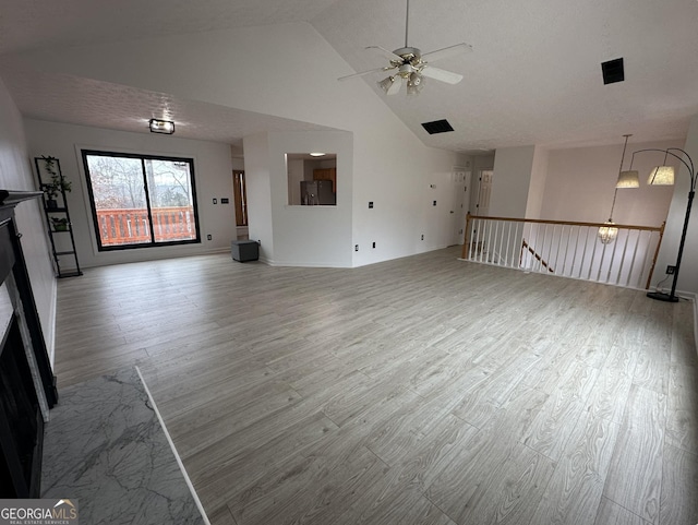 unfurnished living room featuring light wood-type flooring, ceiling fan, and high vaulted ceiling