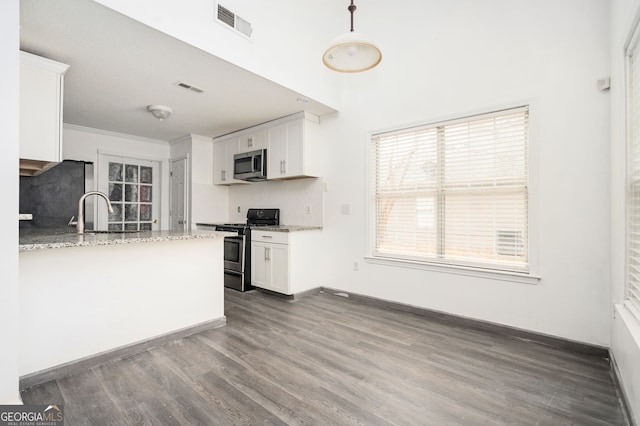 kitchen featuring light stone countertops, appliances with stainless steel finishes, decorative backsplash, and white cabinetry