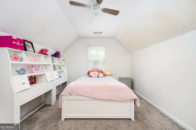 carpeted bedroom with ceiling fan, a textured ceiling, and vaulted ceiling