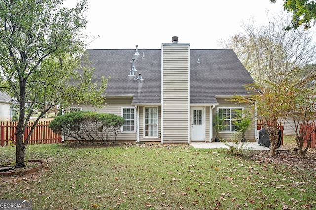 rear view of house featuring a lawn