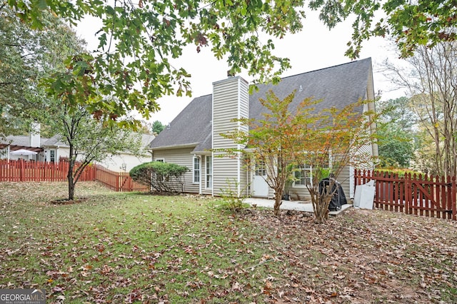 rear view of house featuring a yard and a patio