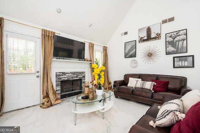 living room with a fireplace and high vaulted ceiling