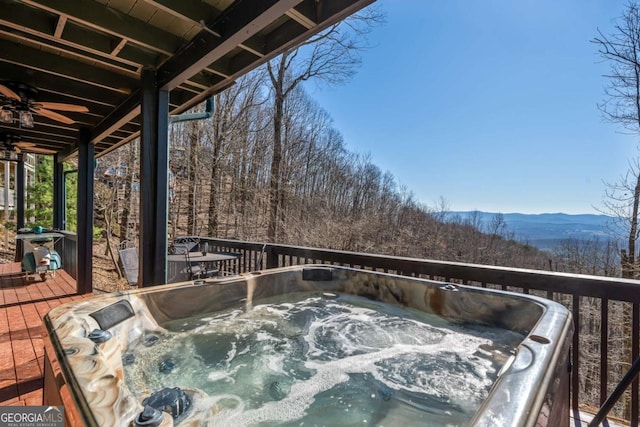 wooden deck with a hot tub and a mountain view