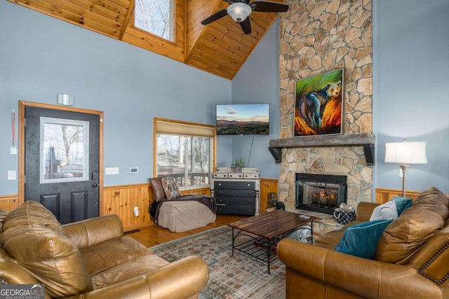 living room with wood ceiling, wood-type flooring, high vaulted ceiling, ceiling fan, and a fireplace