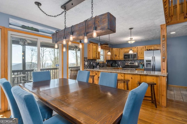 dining space featuring a textured ceiling and light hardwood / wood-style floors