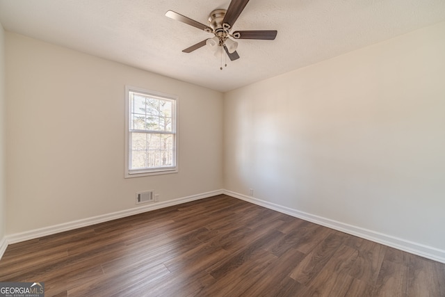 empty room with a textured ceiling, dark hardwood / wood-style flooring, and ceiling fan