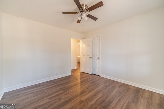 unfurnished room with ceiling fan and dark hardwood / wood-style flooring