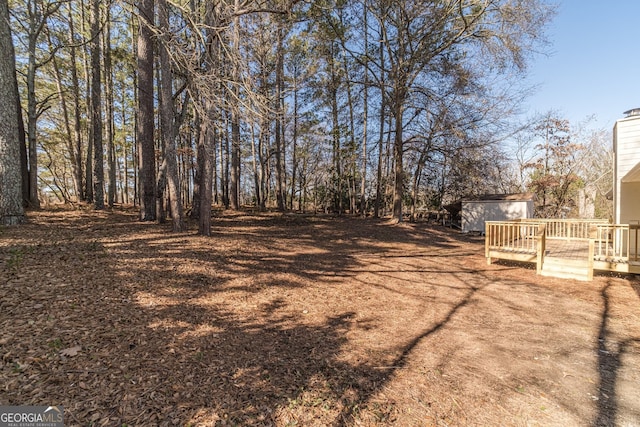 view of yard featuring a storage shed and a deck