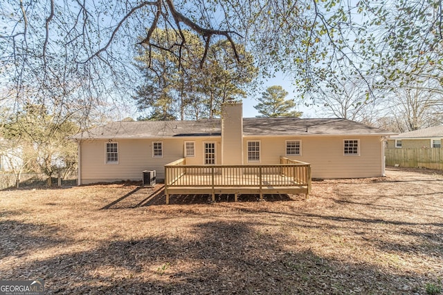 rear view of property featuring cooling unit and a wooden deck