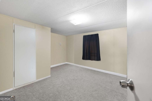 carpeted empty room with a textured ceiling