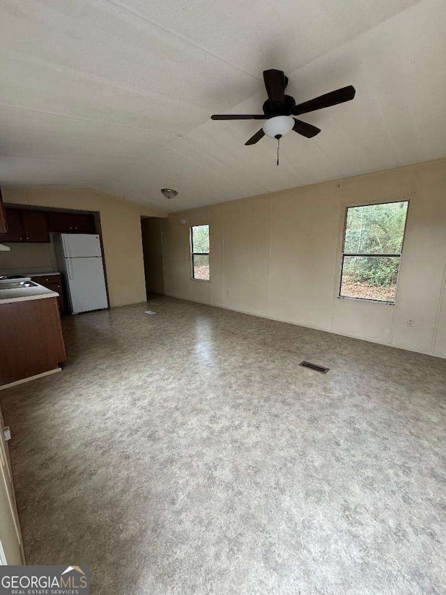 unfurnished living room featuring ceiling fan and a healthy amount of sunlight