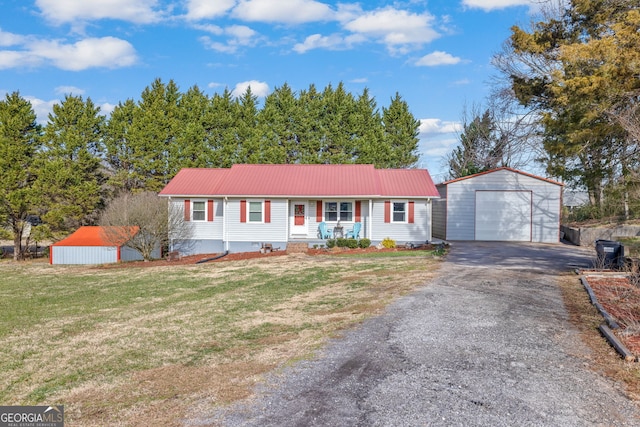 ranch-style home with a garage, covered porch, an outdoor structure, and a front lawn