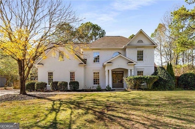 view of front of property with french doors and a front lawn