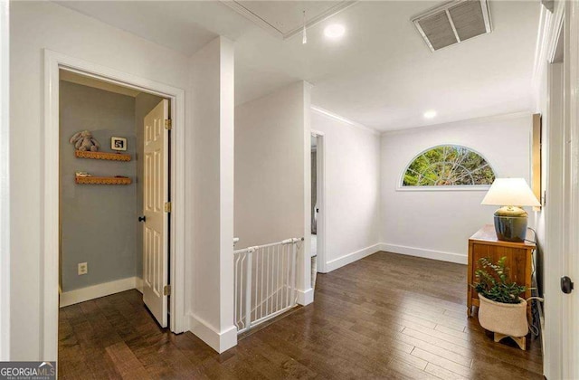 hall featuring crown molding and dark wood-type flooring