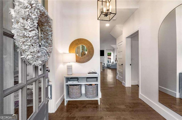 hall featuring a notable chandelier and dark hardwood / wood-style floors