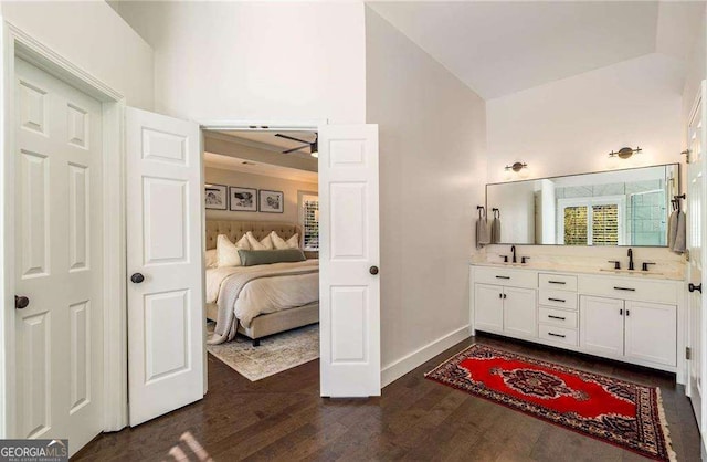 bathroom featuring ceiling fan, vaulted ceiling, vanity, and wood-type flooring