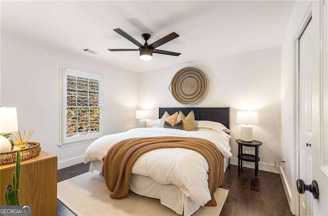 bedroom with dark hardwood / wood-style flooring, a closet, and ceiling fan