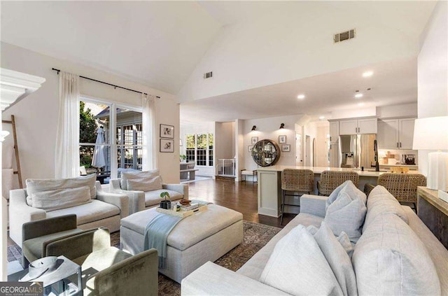 living room with high vaulted ceiling and dark hardwood / wood-style floors